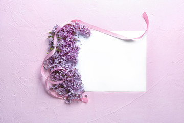 Composition with blank card and blossoming lilac on color background
