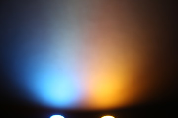 Fototapeta premium Blue and yellow rays of light on a black background
