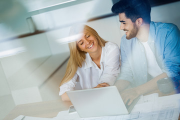 Obraz premium Portrait of a cheerful young couple calculating their bills