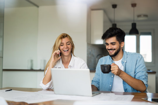 Photo of cheerful loving young couple using laptop