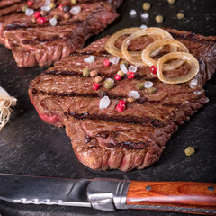 a grilled steak sprinkled with salt and colorful pepper
