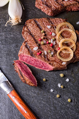 a grilled steak sprinkled with salt and colorful pepper
