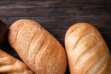Variety of fresh tasty bread on wooden background