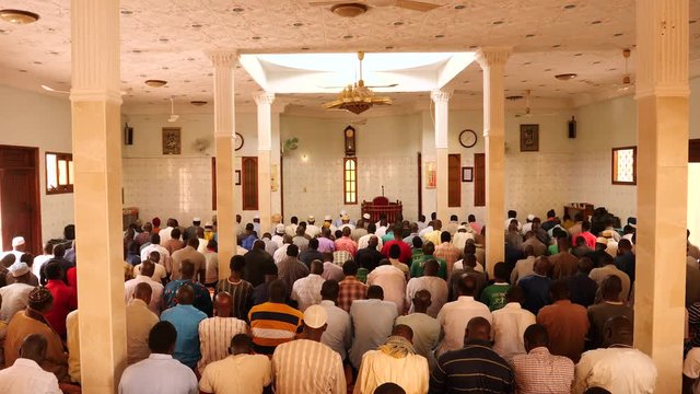 Prayer in African mosque, wide shot of men bowing and rising. Dakar, Senegal.