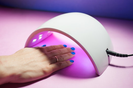 UV lamp gel polish for manicure. A female hand is dried gel nail polish.