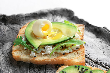 Tasty toast with avocado on plate, closeup