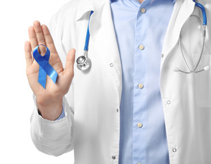 Doctor holding blue ribbon on white background, closeup. Prostate cancer concept