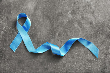 Blue ribbon on grey background. Prostate cancer concept