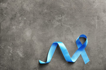 Blue ribbon on grey background. Prostate cancer concept