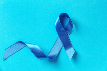 Blue ribbon on color background. Prostate cancer concept