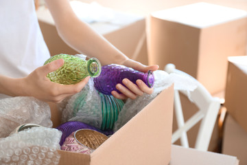 Woman packing carton box indoors. Moving house concept