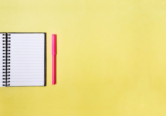 notepad and marker on yellow isolated background