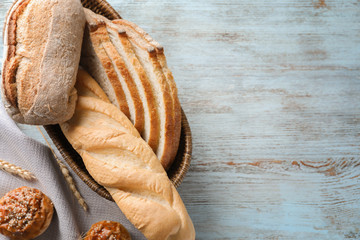 Breadbasket with different bakery products on wooden background