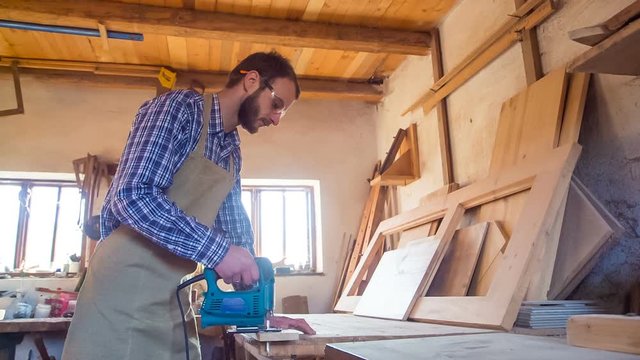 a carpenter working with jig saw and wood
