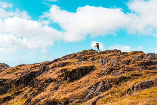 Man Explorer Hiking On The Ridge At The Top Of Mountain