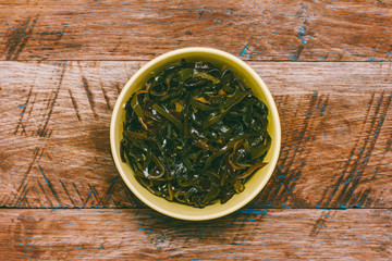 seaweed salad and sesame on a brown wooden grunge background top view close-up