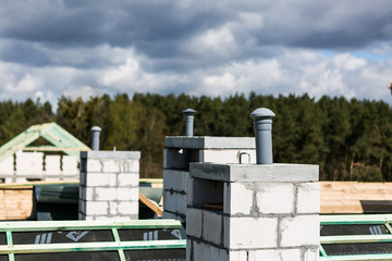 Ventilation chimneys on the construction roof