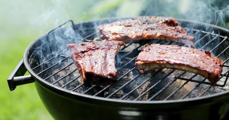 american barbecue - preparing beef ribs on charcoal grill