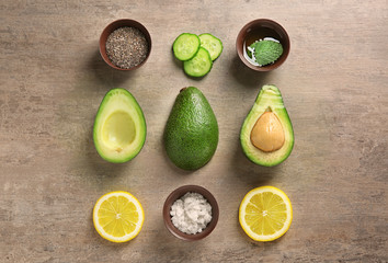 Avocado with ingredients for natural homemade cosmetics on grey background