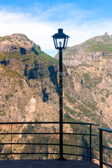Lamppost and railings in a mountainous landscape