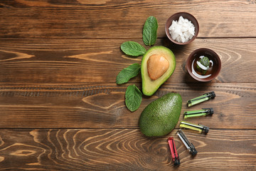 Avocado with ingredients for natural homemade cosmetics on wooden background