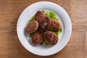 Patties or homemade burgers on white plate. View from above, top studio shot