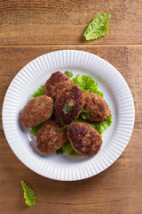 Patties or homemade burgers on white plate. View from above, top studio shot
