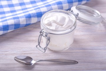 Sour cream in a glass jar. Fresh sour cream