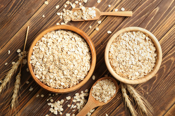 Composition with oatmeal flakes on wooden table, top view