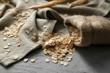 Sack with oatmeal flakes on table
