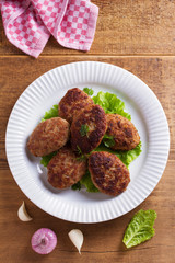 Patties or homemade burgers on white plate. View from above, top studio shot