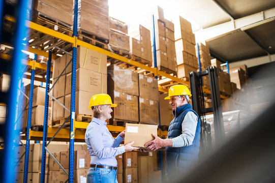 Senior managers or supervisors working together in a warehouse.