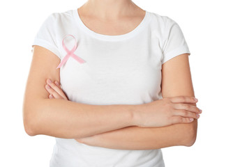 Woman with pink ribbon on t-shirt against white background. Breast cancer awareness concept