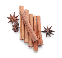 Aromatic cinnamon sticks and anise stars on white background