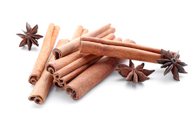 Aromatic cinnamon sticks and anise stars on white background