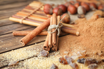 Cinnamon sticks, powder and sugar on wooden background, closeup