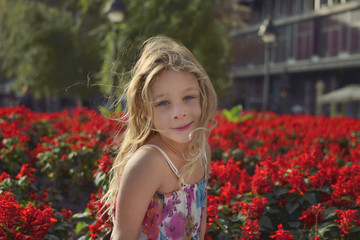 Beautiful blonde girl with red flowers in the background