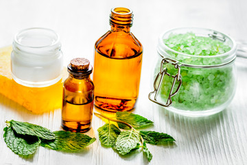 organic cosmetics with herbal extracts of mint on wooden backgro