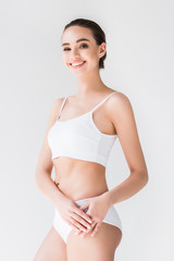 Obraz premium smiling attractive caucasian womanl in white lingerie isolated on gray background