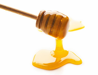 Honey and wooden dipper isolated on white