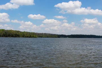 The white cloudscape in the blue sky over the water.