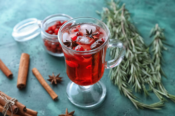 Glass cup of beverage with cranberry and cinnamon on table