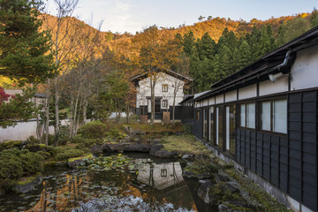Fototapeta na wymiar Ryokan courtyard and pond with hills on the background