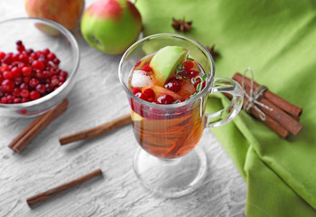 Beverage with apples and cranberry in glass cup on wooden table