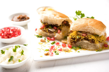 Dabeli is an Indian snack item served with Pomegranate Seeds and Cilantro in white ceramic plate. It's a popular Navratri Festival food