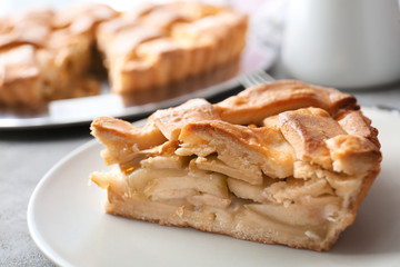 Plate with piece of delicious apple pie on table, closeup