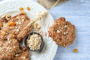 Plate with delicious oatmeal cookies on wooden background, closeup