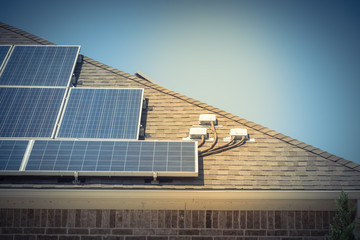 Solar panel system on asphalt shingles rooftop of commercial building in Grapevine, Texas, USA. End...