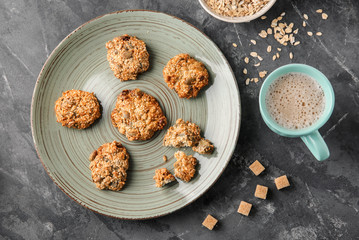 Plate with delicious oatmeal cookies on grey background