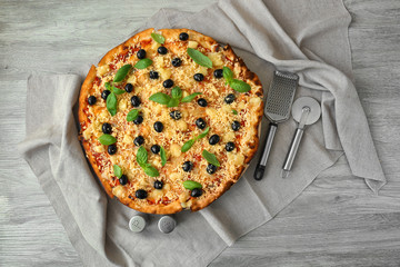 Tasty Italian pizza with olives on wooden table